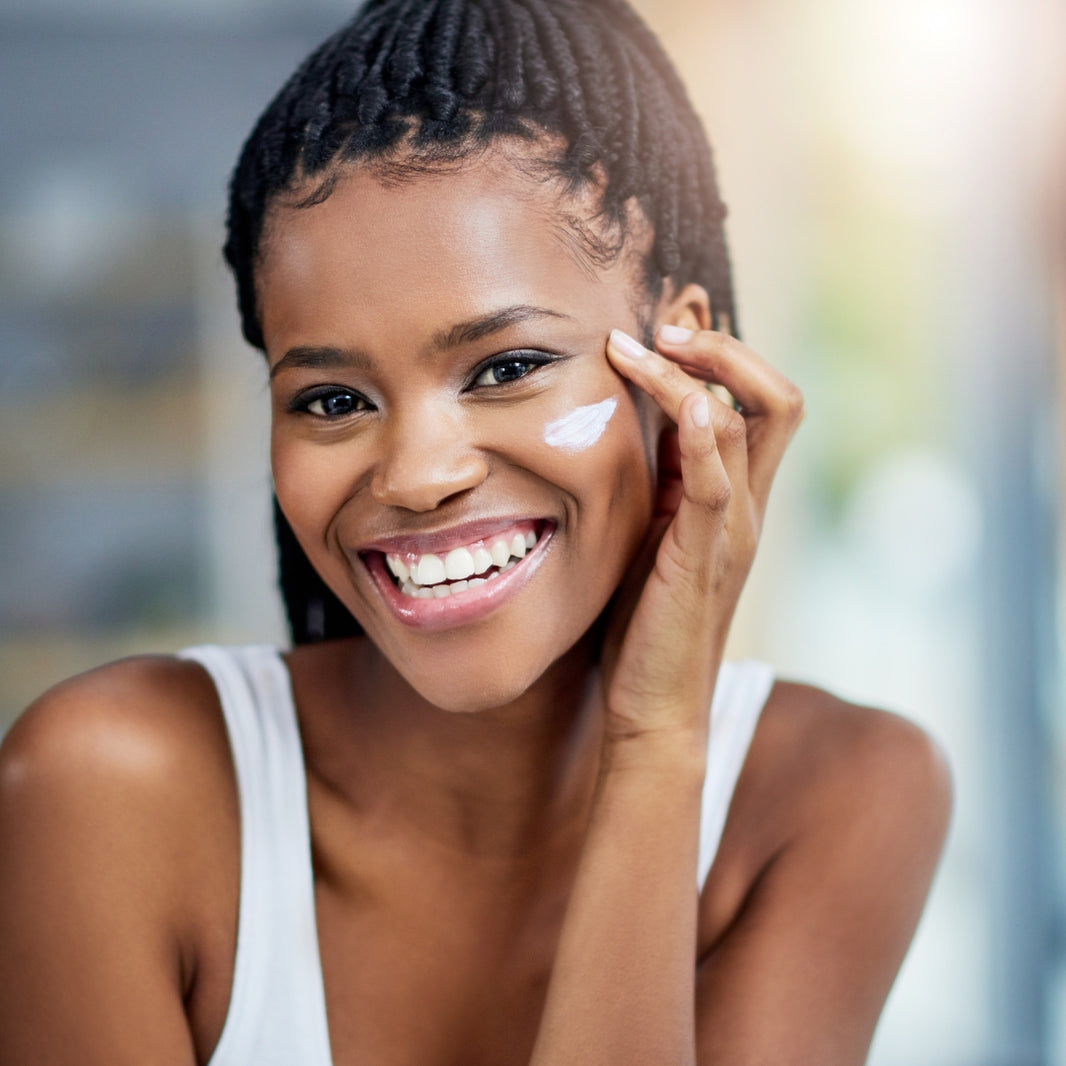 Woman applying cream to her face with a blurred background